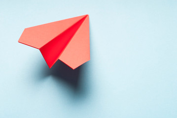 Origami plane on blue background.