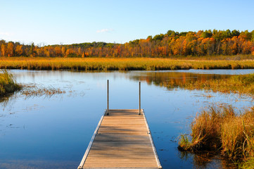 Wooden dock into clear blue lake waters, Fall Colors 