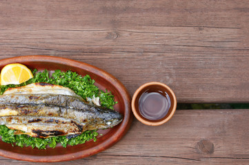 Georgian food. Grilled fish in a clay plate. Grilled Georgian mountain trout