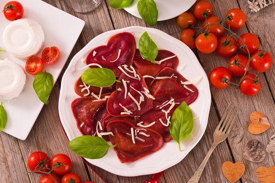 Red heart ravioli with tomato, mozzarella and basil.