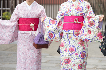 Naklejka premium Young girl wearing Japanese kimono standing in front of Sensoji Temple in Tokyo, Japan. Kimono is a Japanese traditional garment. The word 