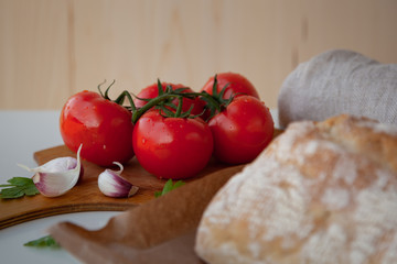 Fresh tomatoes on wooden desk with garlic