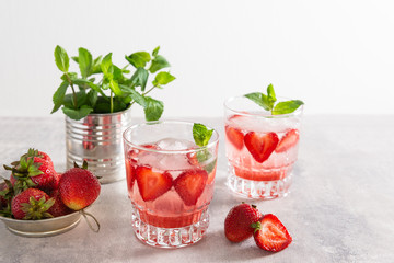 Iced tea in glasses with strawberries and mint. On a white background.
