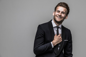 Portrait of a smiling handsome model in a classic black and white style clothing. Studio shot. Copy space.