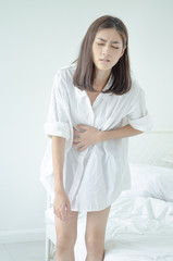 Naklejka premium Asian girl has abdominal pain.When is menstruation.Catch his stomach.Women have bladder pain.Do not focus on objects