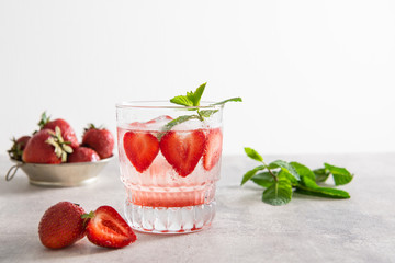 Refreshing Ice Cold Strawberry Lemonade in glas on a grey background. Copy space. For menu, banner
