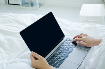 Beautiful Asian woman is smiling.Lady work with laptops on the sofa in the room in the morning.She is happy to get a new job, success, or get good news.Do not focus on the main object of this image.