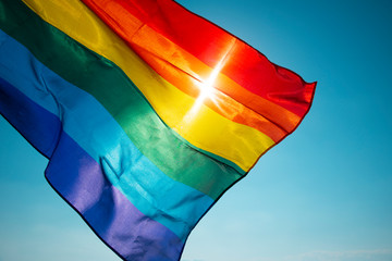 rainbow flag waving on the blue sky - obrazy, fototapety, plakaty
