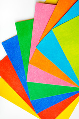 Various colorful sheets of cardboard on a white background, vertical top view