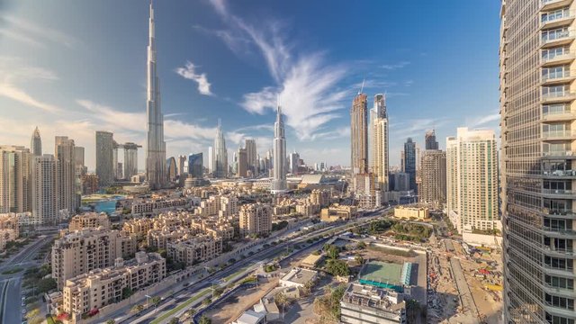 Dubai Downtown skyline timelapse with Burj Khalifa and other towers paniramic view from the top in Dubai, United Arab Emirates. Traditional and modern buildings. Traffic on circle road and fountains