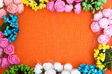 Frame of bright artificial flowers - multi-colored, background