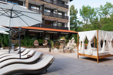Swimming pool area with white sun beds. Summer vacation