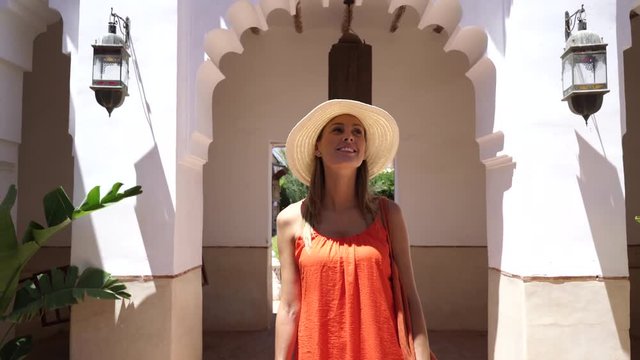Stunning woman in bright dress exploring Moroccan riad and gardens
