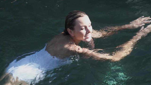 Slow motion of stunning woman swimming in pool