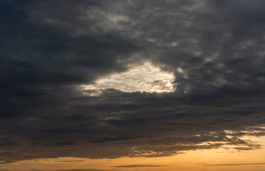 Naklejka na ściany i meble Dark Cloudscape at Sunset with a Hole in the Sky