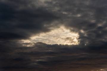 Dark Cloudscape at Sunset with a Hole in the Sky