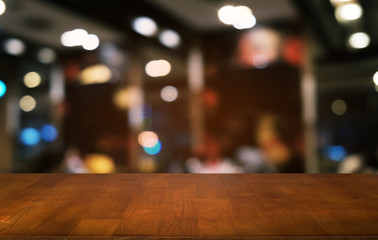 Empty dark wooden table in front of abstract blurred bokeh background of restaurant . can be used for display or montage your products.Mock up for space.