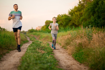 Obraz premium Father and daughter jogging. Cheerful father and daughter run in park together. Sport life concept
