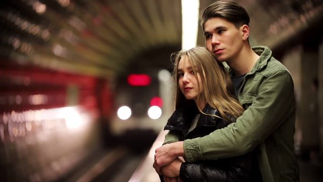 A young couple standing in the subway and waiting for the train