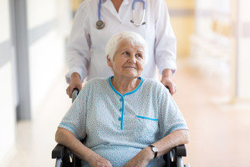 Senior woman in wheelchair with doctor in hospital