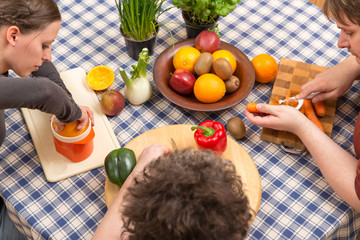 3 Personen am Tisch mit Gemüse und Obst