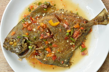 deep fried white pomfret dressing spicy sauce on plate