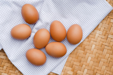 Brown eggs lay on a white plaid fabric. Healthy food concepts.