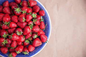 A large bright blue dish with ripe strawberries. View from above. Concept of summer mood and healthy eating.