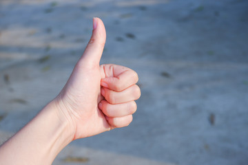 The hands of women lifted their thumbs on blurred background. The concept of expressing opinions with sign language.