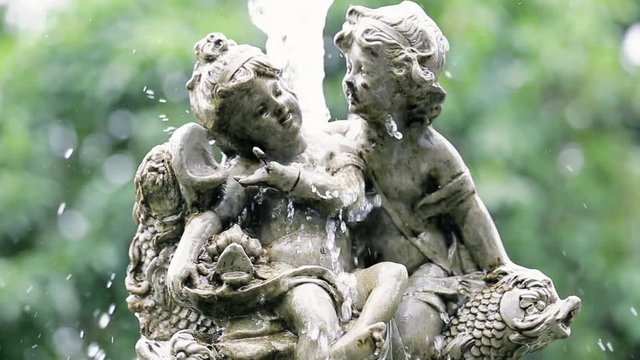 A fountain with two angels in the park with blur background