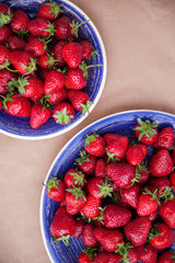 Two bright blue plates with ripe strawberries. View from above. Healthy eating concept