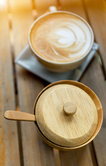 Wooden sugar bowl and coffee late, morning warm light, wooden product design