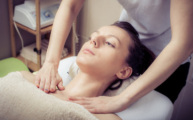 Beautiful woman relaxing with face massage at luxury spa salon