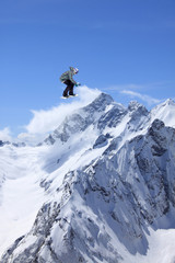 Naklejka na ściany i meble Flying snowboarder on mountains, extreme sport