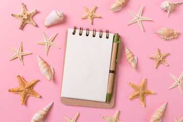 Fototapeta na wymiar blank note book with starfish or seashells on a pink background , summer vaction concept