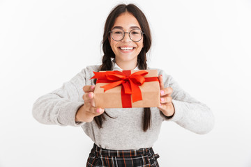 Fototapeta premium Photo closeup of delighted teenage girl wearing eyeglasses smiling while holding present box with red bow