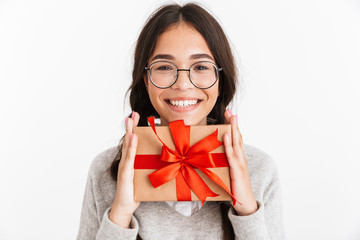 Excited young school girl isolated over white wall background holding surprise box gift.