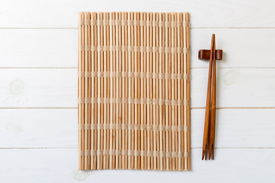 chopsticks and sushi roll on bamboo mat. background menu Stock Photo - Alamy