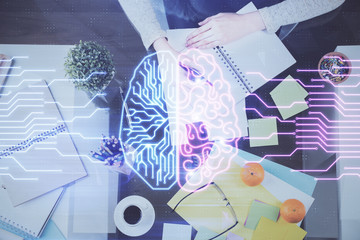 Double exposure of writing hand on background with brain hologram. Concept of learning.