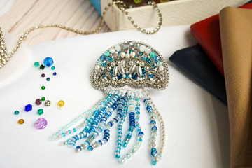 Handmade beaded jellyfish blue on table on white background