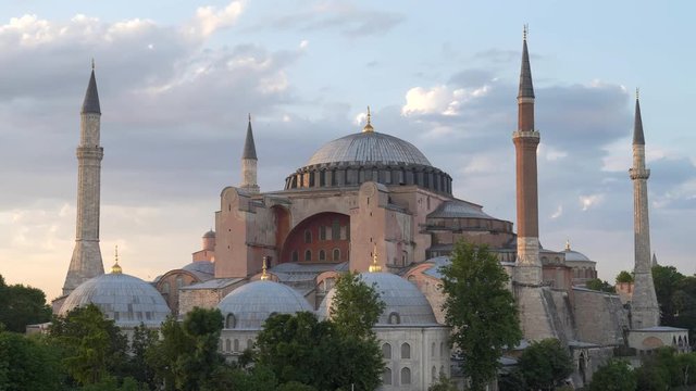 seagulls fly around hagia sophia mosque at sunset in stanbul, turkey