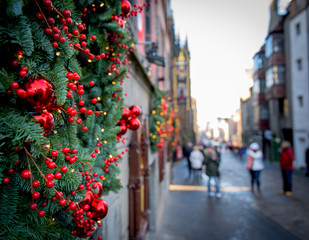 Christmas tree decorated on the wall with red balls. Blurred street in the background 