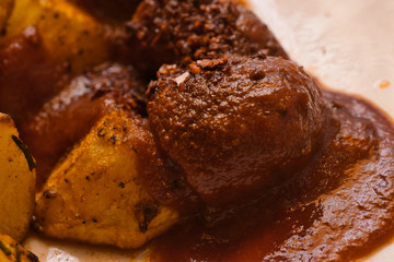 German-style currywurst with lots of paprika powder and curry powder in a ketchup sauce on baked potatoes, food