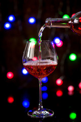 glass of wine with lights in background