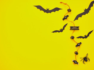 Decorative spiders and bats on yellow background