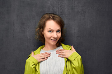 Portrait of surprised girl pointing to herself