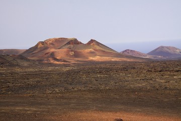 Fototapeta na wymiar View over barren wide plain on red volcano crater - Timanfaya NP, Lanzarote
