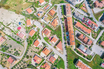 Aerial view town with houses and ceramic tiles, solar panels, streets.