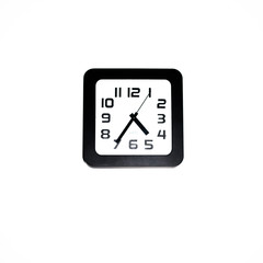 Wall clock - square black wall clock on a white wall