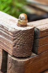 Metal bolt connecting the two parts of the wooden box in the garden - Image
